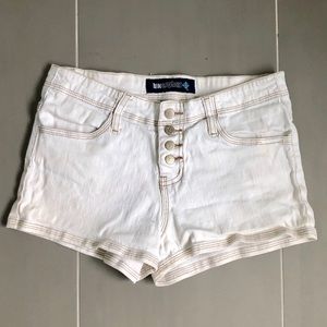 White denim shorts with tan stitching